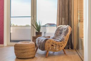 格赫伦-莱宾Luxus Spa Penthouse Sundowner的窗户房间里摆放着藤椅和凳子