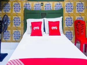 古邦OYO 2518 Wilma Hotel Ii Premier的一间卧室配有红色枕头的床
