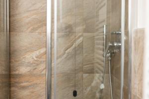 利维尼奥BAITA NOEMI的浴室里设有玻璃门淋浴