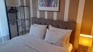 阿吉亚特拉萨佛得角旅馆的一张带白色枕头的床和一张墙上的照片