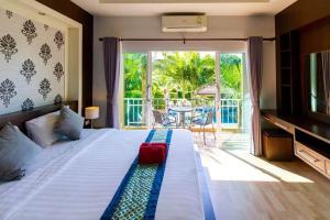 高兰Phutara Lanta Resort - SHA Extra Plus Koh Lanta的一间卧室配有一张床,阳台配有桌子