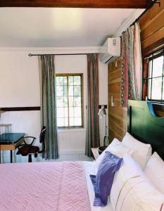 欧丘里欧Hidden Gem @ White River Ocho Rios - Secluded Retreat for Four的卧室配有床、桌子和窗户。