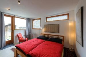 哈尔施塔特阁楼安西酒店的一间卧室配有红色的床和红色椅子