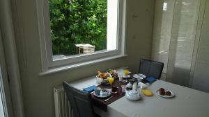 根特B&B Maaltebrug的一张桌子,上面有食物,有窗户