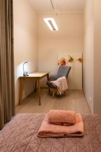 塔尔图Dorpat Apartment的一间卧室配有书桌、桌子和椅子