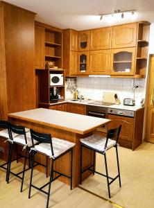 柴尔凯瑟勒Csiribá Apartman的厨房配有木制橱柜和桌椅