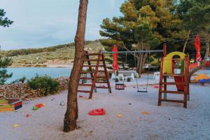 苏佩塔尔Boutique Camping Bunja的树旁海滩上的游乐场
