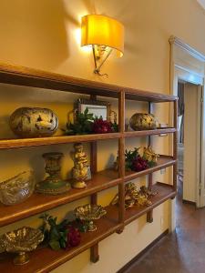 拉文纳卡萨马索利酒店的墙上装满板子和花瓶的架子