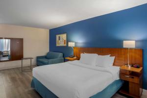 劳雷尔山Comfort Inn & Suites Mt Laurel-Philadelphia的一间卧室设有一张大床和蓝色的墙壁