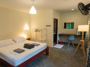 哈林海滩House of Sanskara的一间卧室配有一张床、一张桌子和一把椅子