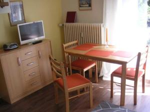 宁多夫PAR7b "Haus Miramar" App Rothmund的客房设有桌子、电视和桌椅。