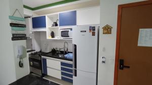 乌巴图巴Apartamento Resort Palmeiras 2 com 03 Quartos Ubatuba的小厨房配有冰箱和微波炉。