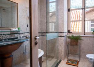杜布罗夫尼克普谢克宫殿酒店的一间带玻璃淋浴和水槽的浴室