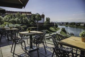 克拉科夫波德瓦维尔酒店的一个带桌椅的河景庭院