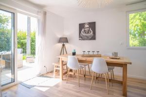 拉特斯特德布赫Villa Nina- Maison cocon cosy的一间带木桌和白色椅子的用餐室