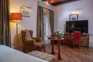杜布罗夫尼克普谢克宫殿酒店的酒店客房配有一张床、一张书桌和一台电视。