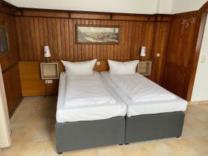 伊德施泰因Hotel Sonne - Haus 2的木镶板客房内的两张床