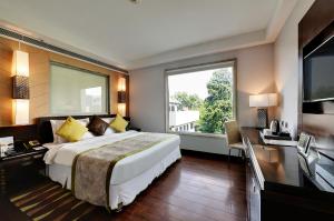 古尔冈Quality Inn Gurgaon的一间卧室设有一张大床和一个大窗户