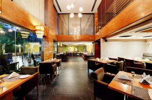 古尔冈Quality Inn Gurgaon的用餐室配有木桌和椅子