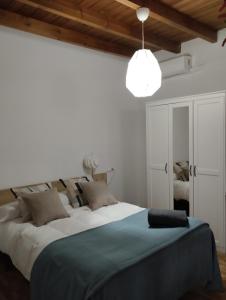 塞维利亚Azahar的一间卧室配有一张大床和吊灯