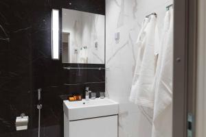 赫尔辛基Hotel Bastian的黑白浴室设有水槽和镜子