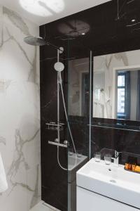 赫尔辛基Hotel Bastian的黑白浴室设有淋浴和水槽