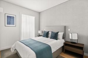 里斯本Mirabilis Apartments - AAA23的一间卧室配有一张带蓝色枕头的大床
