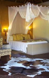 AlldaysMogalakwena River Lodge的一间卧室配有一张带天蓬的床