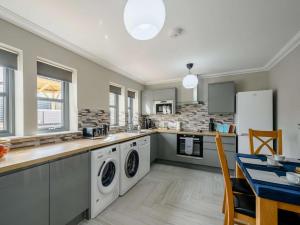 巴洛赫Westertonhill Lodge 3 with Hot Tub Option的厨房配有洗衣机和烘干机