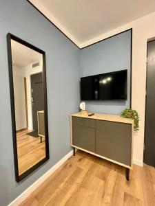 拉多姆Przytulne mieszkanie w centrum miasta的一间设有镜子和带电视的梳妆台的房间