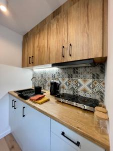 拉多姆Przytulne mieszkanie w centrum miasta的厨房配有木制橱柜和炉灶烤箱。