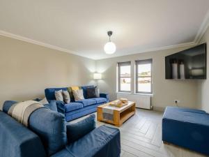巴洛赫Westertonhill Lodge 3 with Hot Tub Option的客厅配有蓝色的沙发和电视