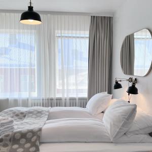 雷克雅未克Hotel Local 101的白色卧室设有一张大床和镜子