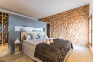 马纳科尔Ideal Property Mallorca - Pleta 8 PAX的一间卧室设有一张床和石墙
