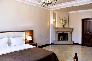 第比利斯Hotel Gremi Tbilisi的一间卧室配有一张床和一个壁炉