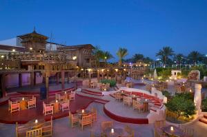 沙姆沙伊赫Jaz Sharm Dreams的一间晚上带桌椅的户外餐厅