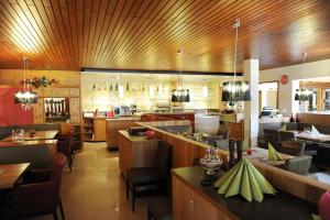 腓特烈港Hotel Hellers Twenty Four II -24h-Check-In-的餐厅设有木制天花板和桌椅