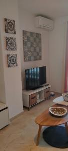 埃尔波提尔Coqueto apartamento a un tiro de piedra de la playa del Portil的客厅配有电视和桌子