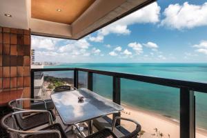 福塔莱萨Particular Iracema Residence的一个带桌椅的海景阳台