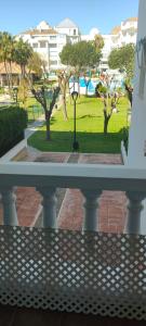 埃尔波提尔Coqueto apartamento a un tiro de piedra de la playa del Portil的阳台享有公园的景致。