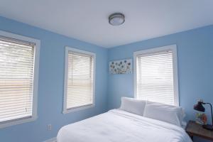 杰克逊维尔海滩Central & Comfortable Home Walk to the Beach!的一间蓝色卧室,配有床和2个窗户
