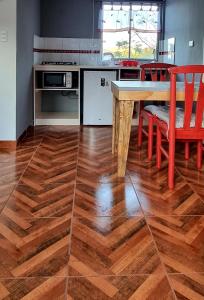 安加罗阿Henua Roa Loft的厨房铺有木地板,配有桌椅。