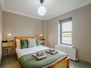 巴洛赫Westertonhill Lodge 4 Newbuild with Hot Tub Option的一间卧室配有带毛巾的床