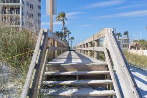 杰克逊维尔海滩Central & Comfortable Home Walk to the Beach!的海滩上沙子上的木桥