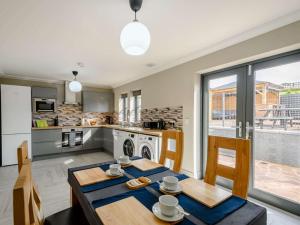 巴洛赫Westertonhill Lodge 4 Newbuild with Hot Tub Option的厨房以及带桌椅的用餐室。