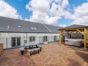 巴洛赫Westertonhill Lodge 4 Newbuild with Hot Tub Option的天井设有2张长椅和1张野餐桌