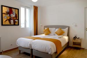巴黎Les Rebelles的一间卧室配有一张带黄色枕头的大床