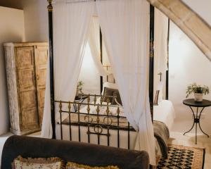 洛弗Apanemia Inn Studio的一间卧室配有带窗帘的黑色天蓬床