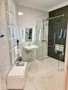 杰尔Hotel Domus Collis的白色的浴室设有水槽和淋浴。