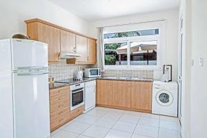普罗塔拉斯Villa Attis的厨房配有木制橱柜和白色冰箱。
